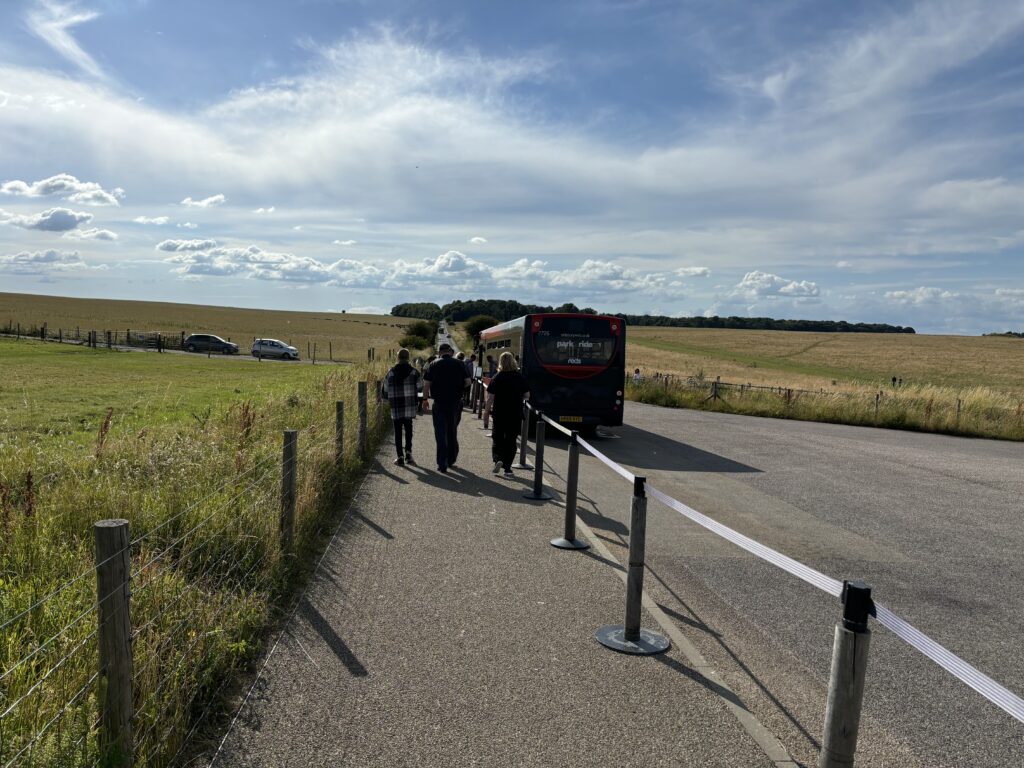 a group of people walking on a road with a bus