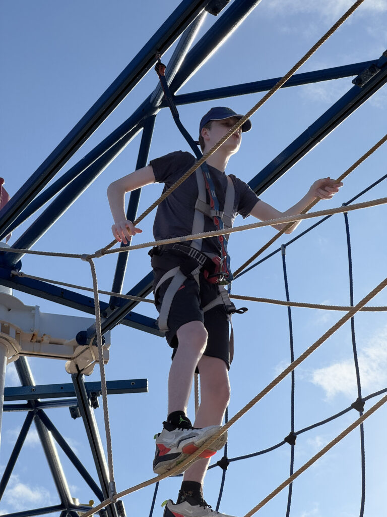 a boy climbing a rope structure