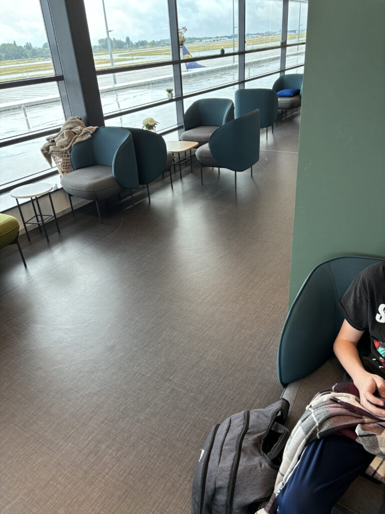 a person sitting on the floor in a room with chairs and a window