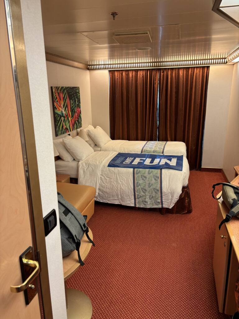 a room with two beds and a backpack