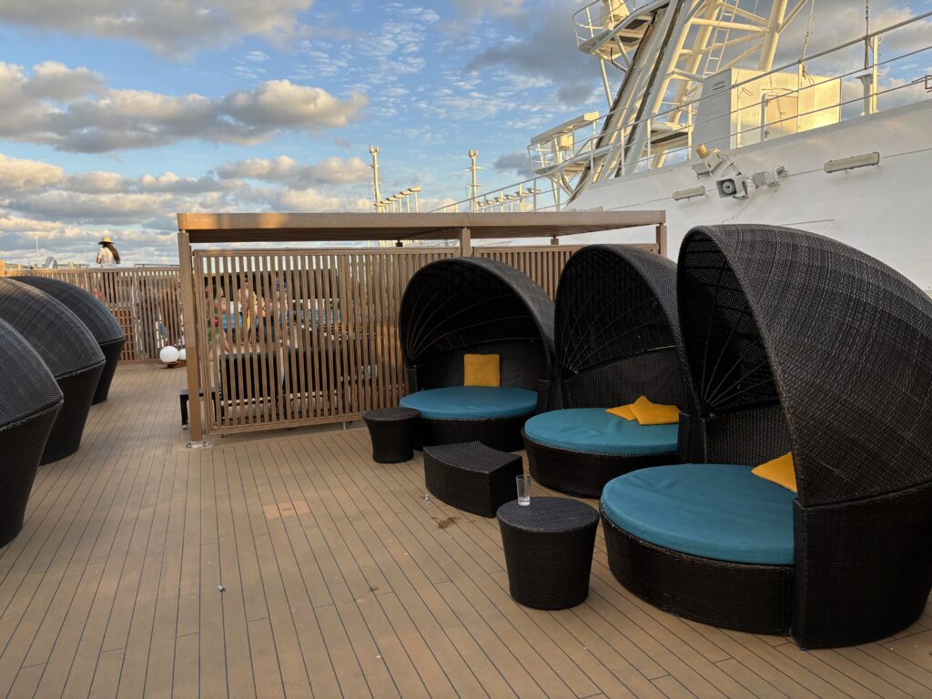a deck with wicker chairs and a boat