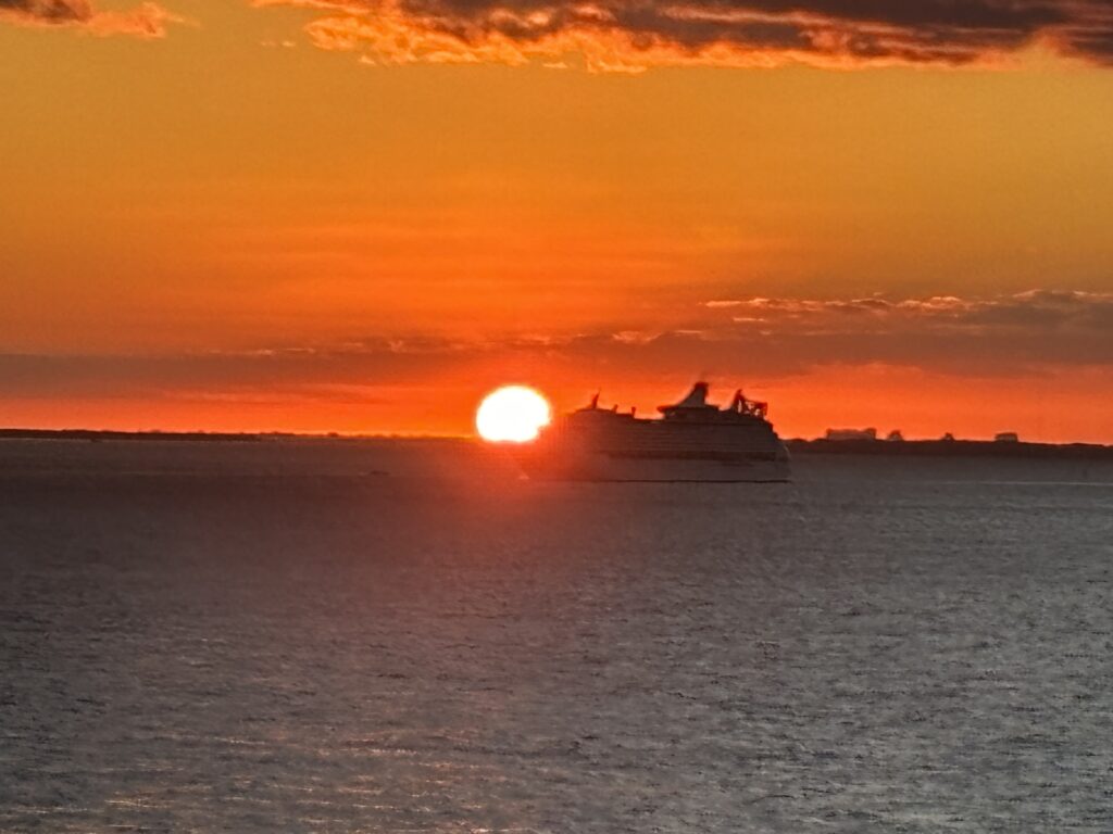 a ship in the water at sunset