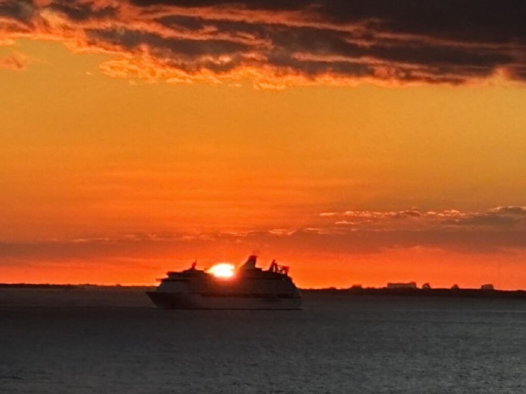 a ship in the water at sunset