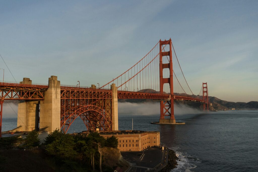 a bridge over water with a building and trees
