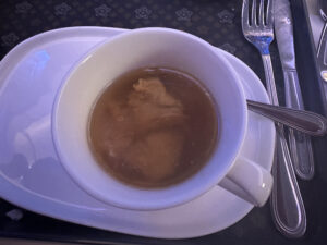 a cup of soup on a plate