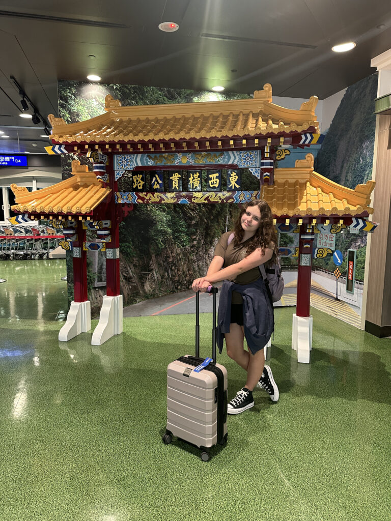 a woman standing next to a suitcase