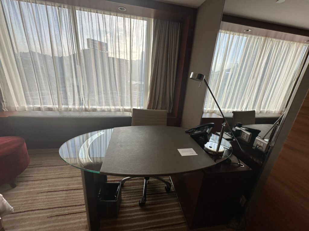 a room with a round table and a lamp