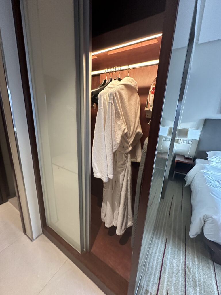 a closet with white bathrobes and swingers