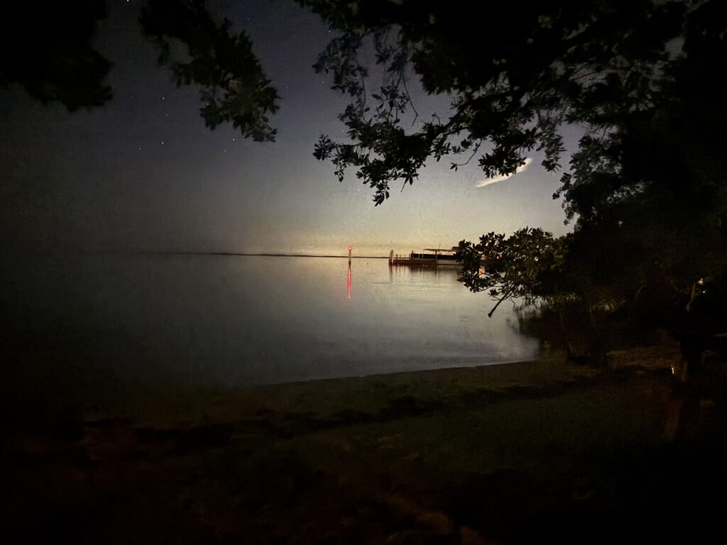 a body of water with a dock and a boat in the distance
