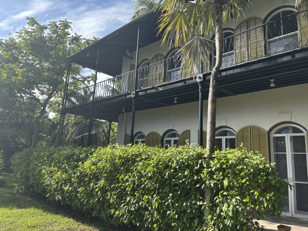 a building with a balcony and bushes