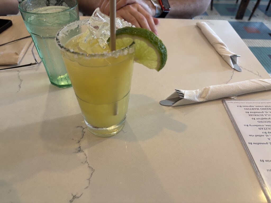a glass with a lime wedge and ice on a table