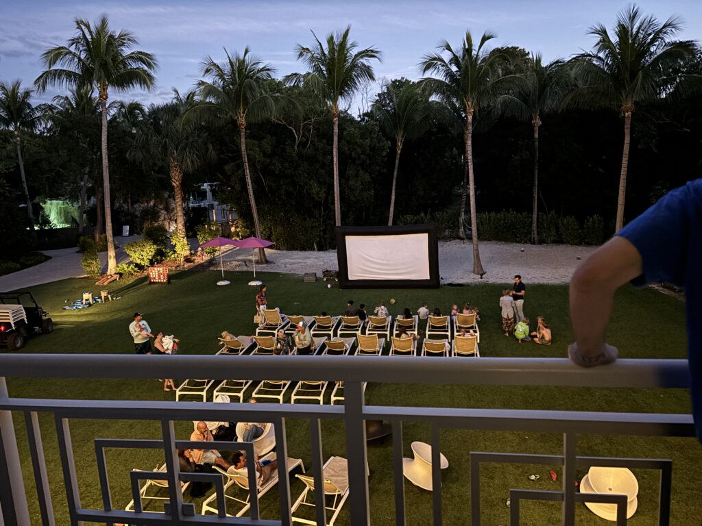 a group of people sitting in chairs outside in a movie theater