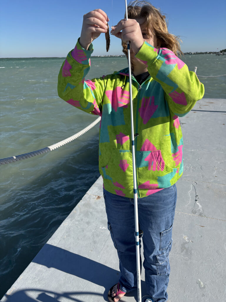 a girl holding a fish in front of water