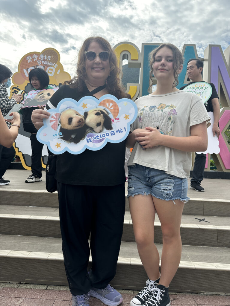 a woman and a girl holding up a sign