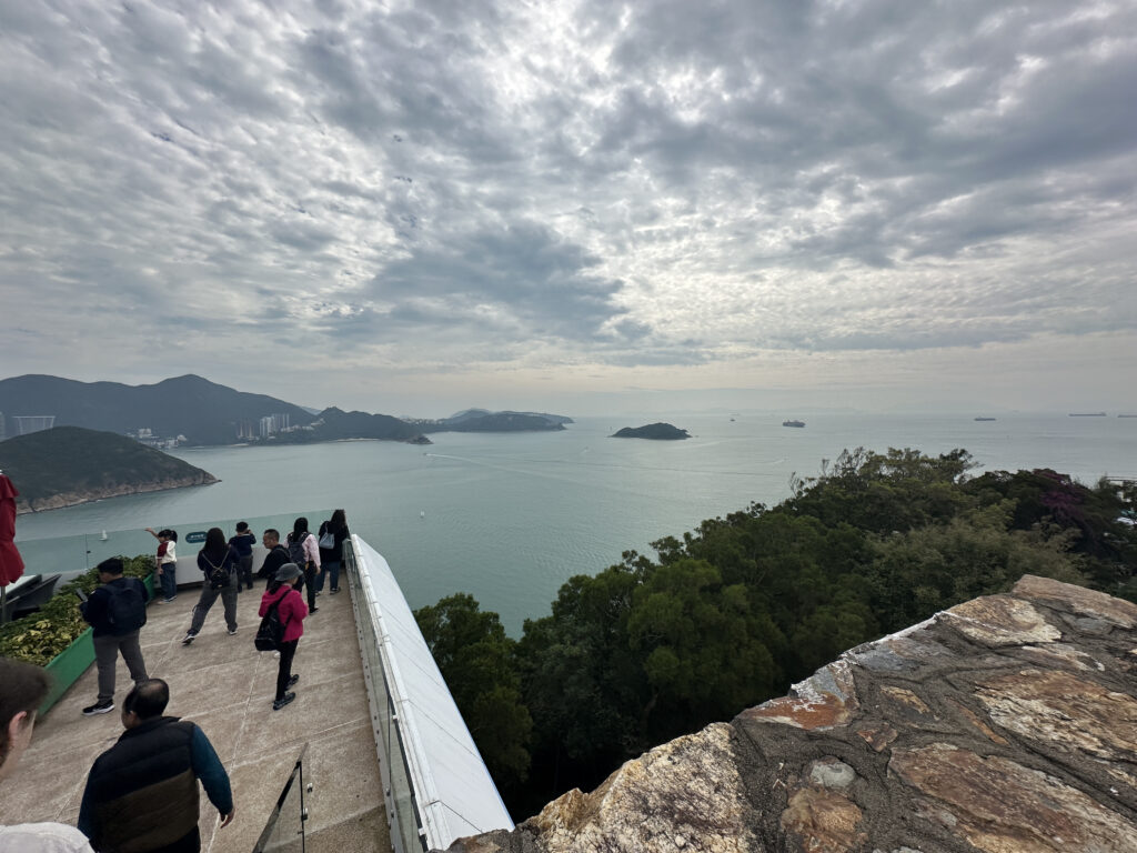 a group of people on a ledge overlooking a body of water