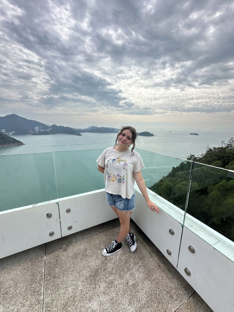 a woman standing on a balcony overlooking a body of water