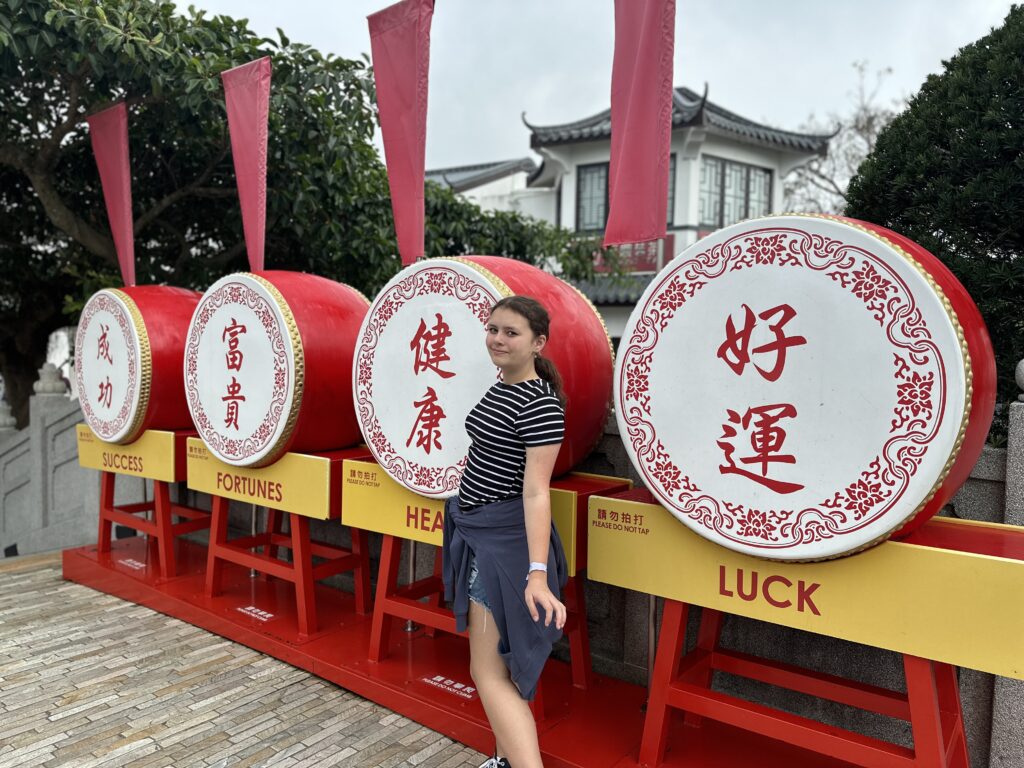 a woman standing in front of a row of drums