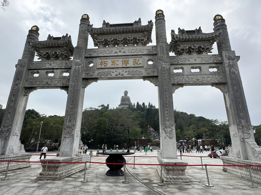 a large stone archway with a statue in the background