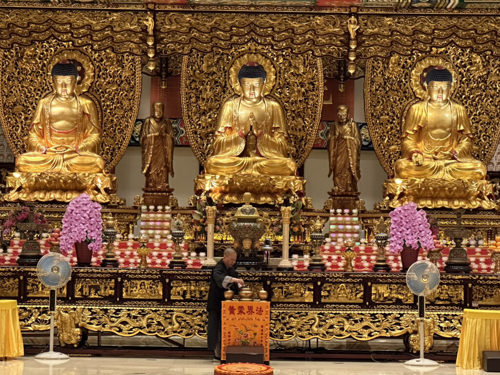 a man standing in front of a large gold statue