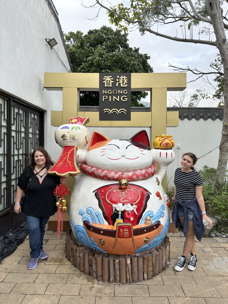 two women standing next to a statue