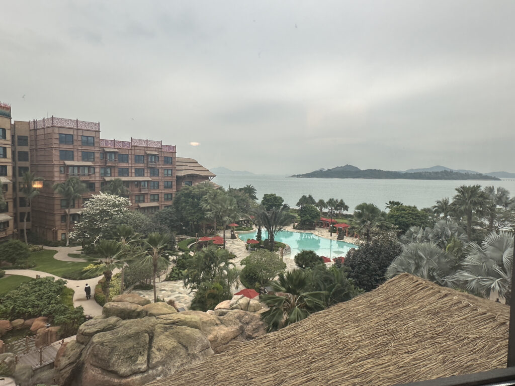 a pool and a building with a body of water in the background