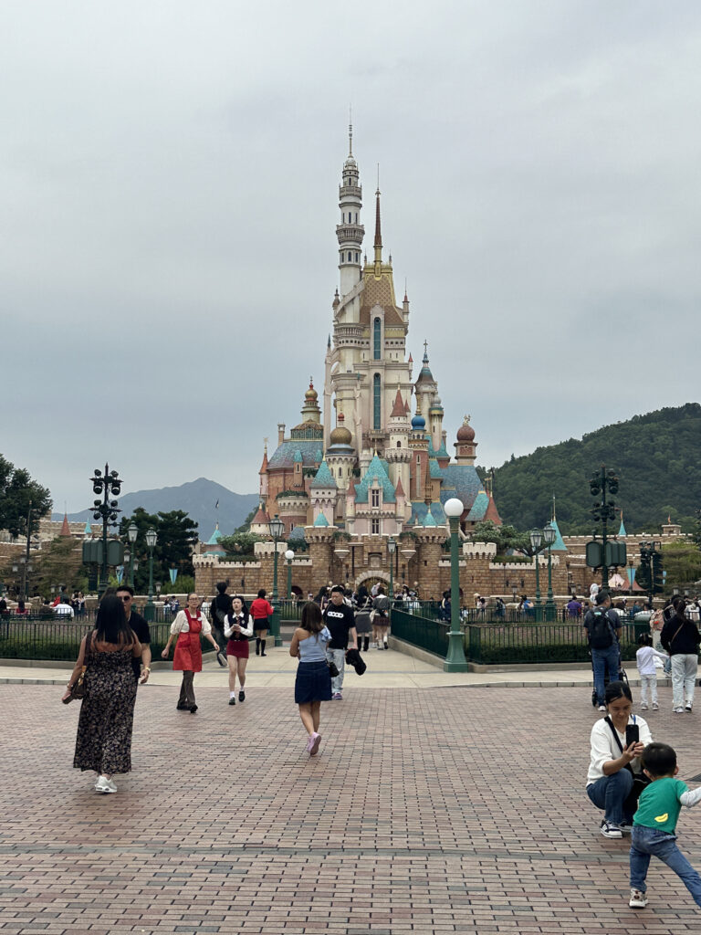 a group of people walking in front of a castle