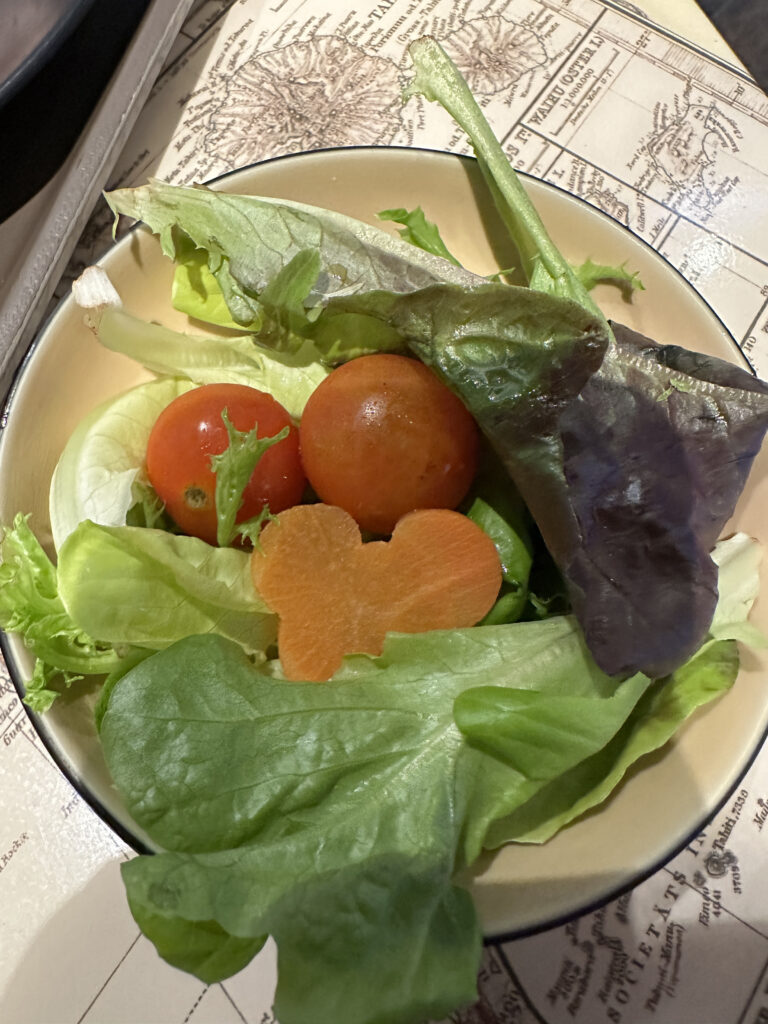 a bowl of salad with tomatoes and carrots
