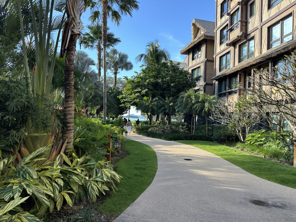 a walkway with palm trees and buildings