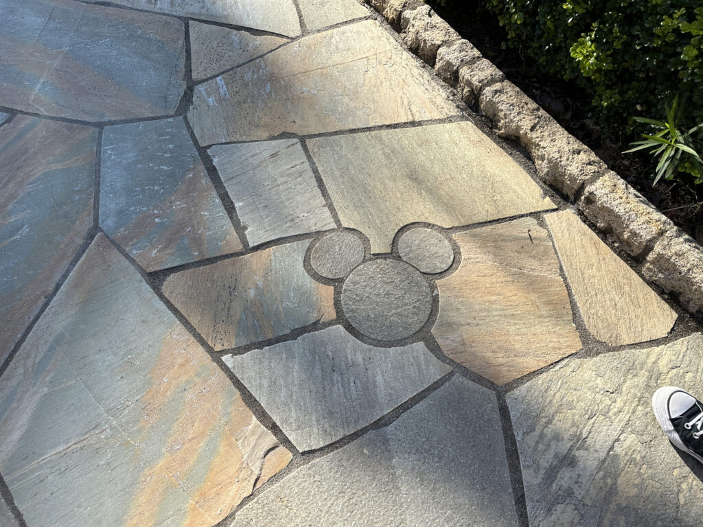 a stone walkway with a cartoon mouse symbol