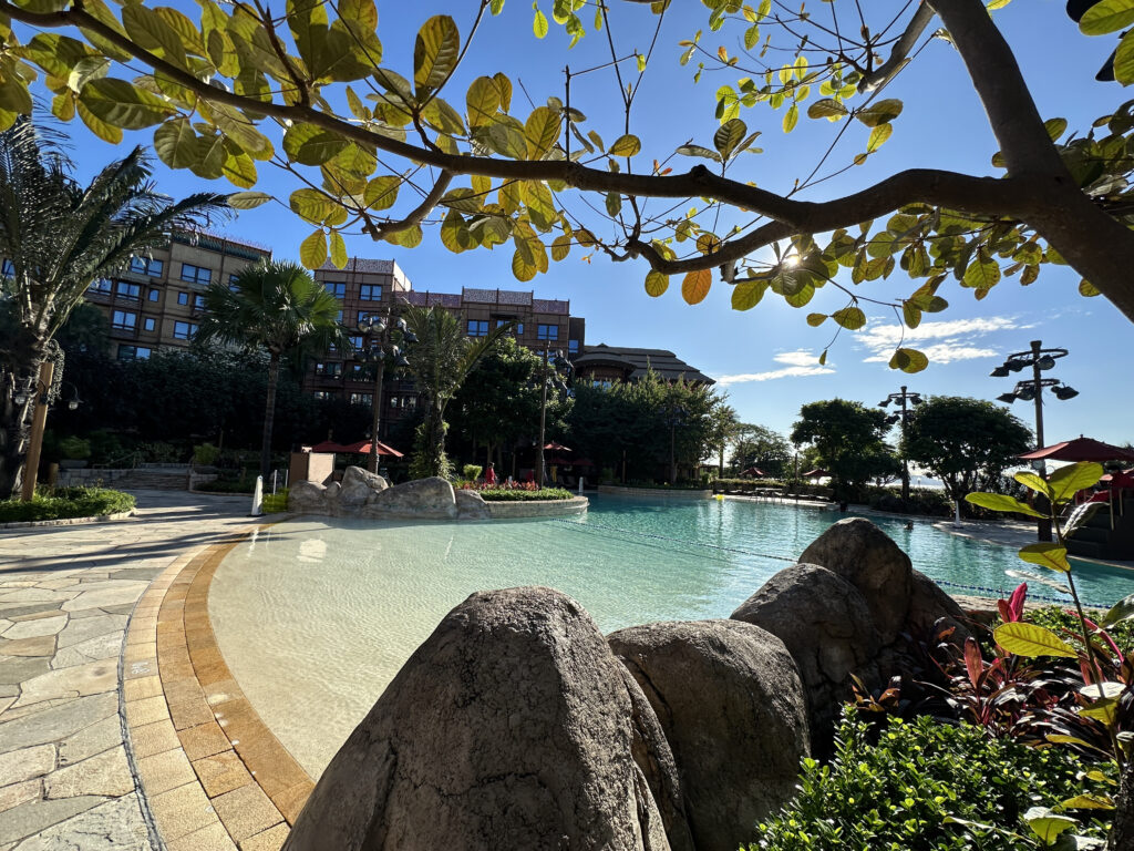 a pool with rocks and trees in the background