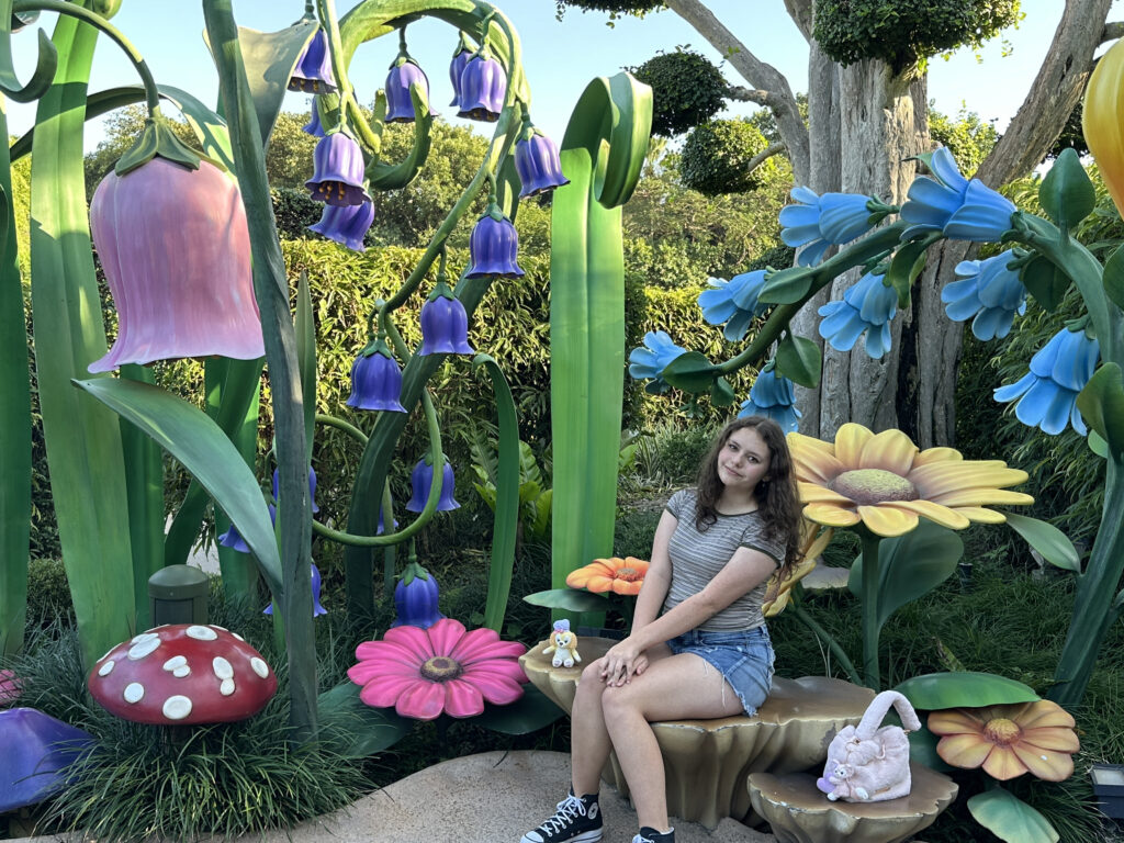 a woman sitting on a bench in a garden