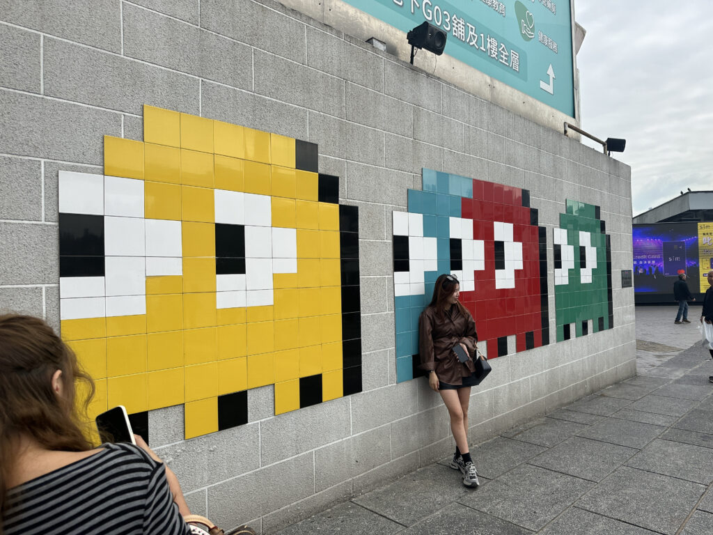 a woman standing next to a wall with a cartoon character