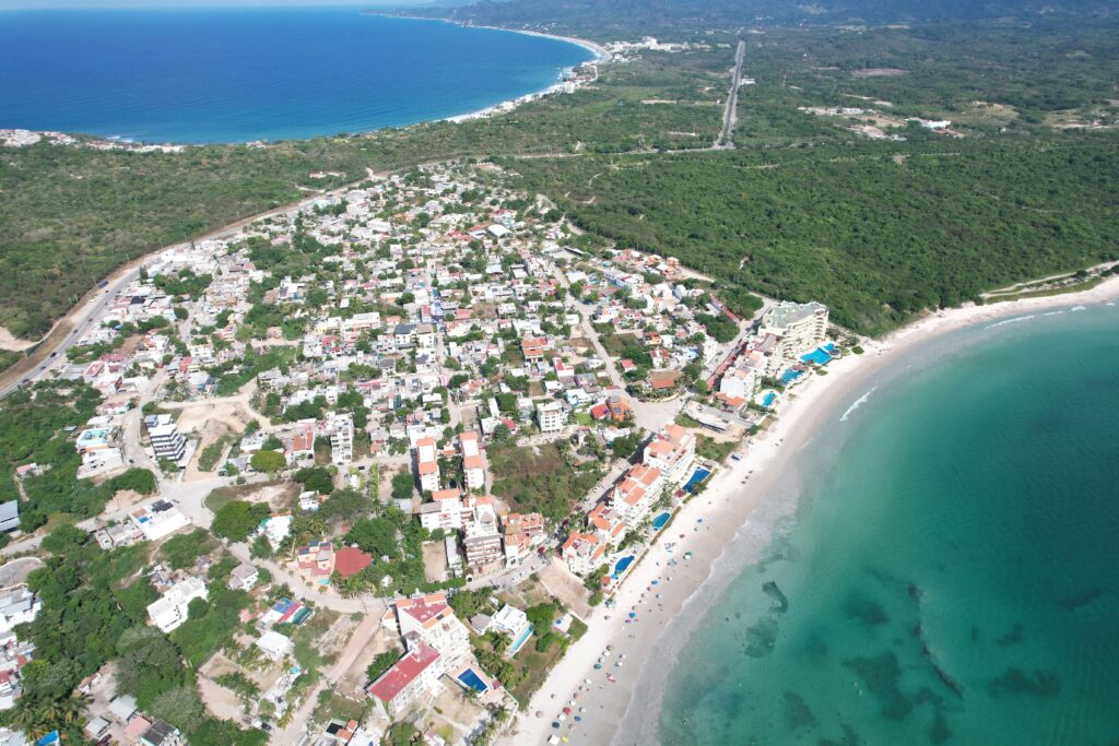 an aerial view of a beach with buildings and trees