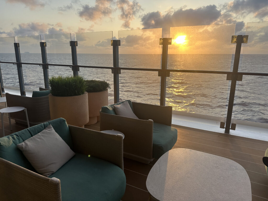 a deck with chairs and a table overlooking the water