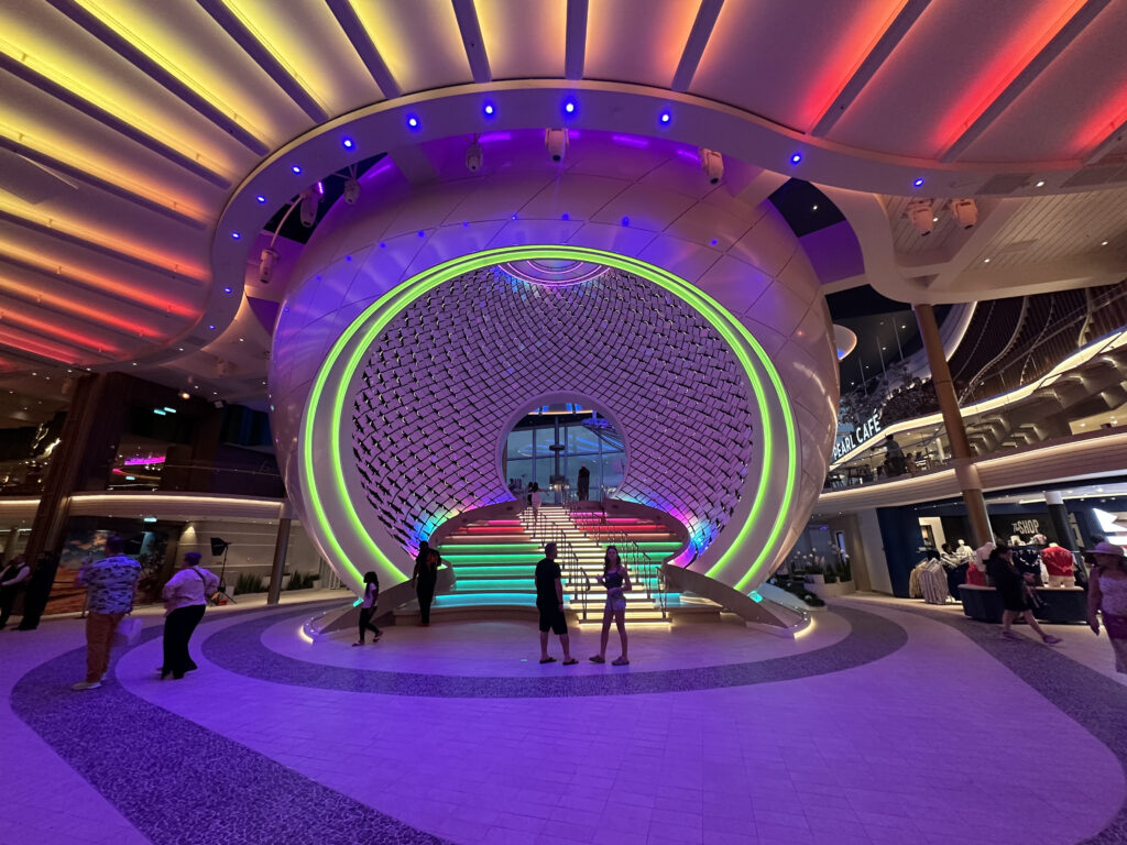 a group of people inside a building with colorful lights