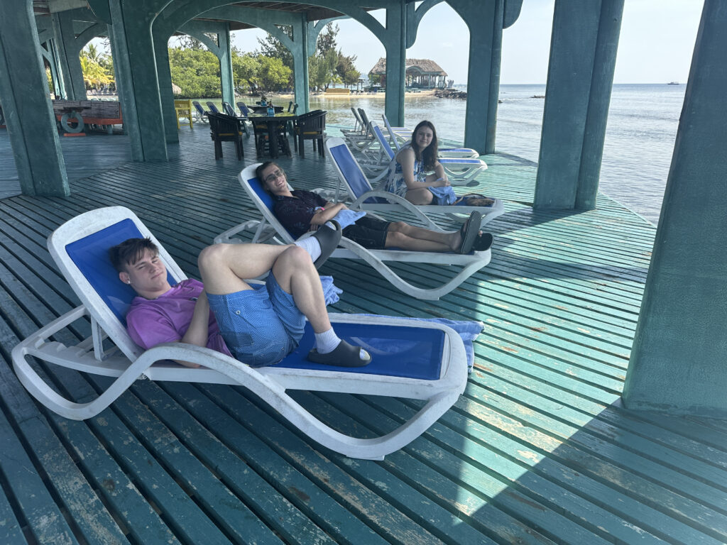 a group of people sitting on lounge chairs under a gazebo