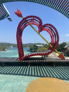 a red heart shaped sculpture with an arrow in the middle