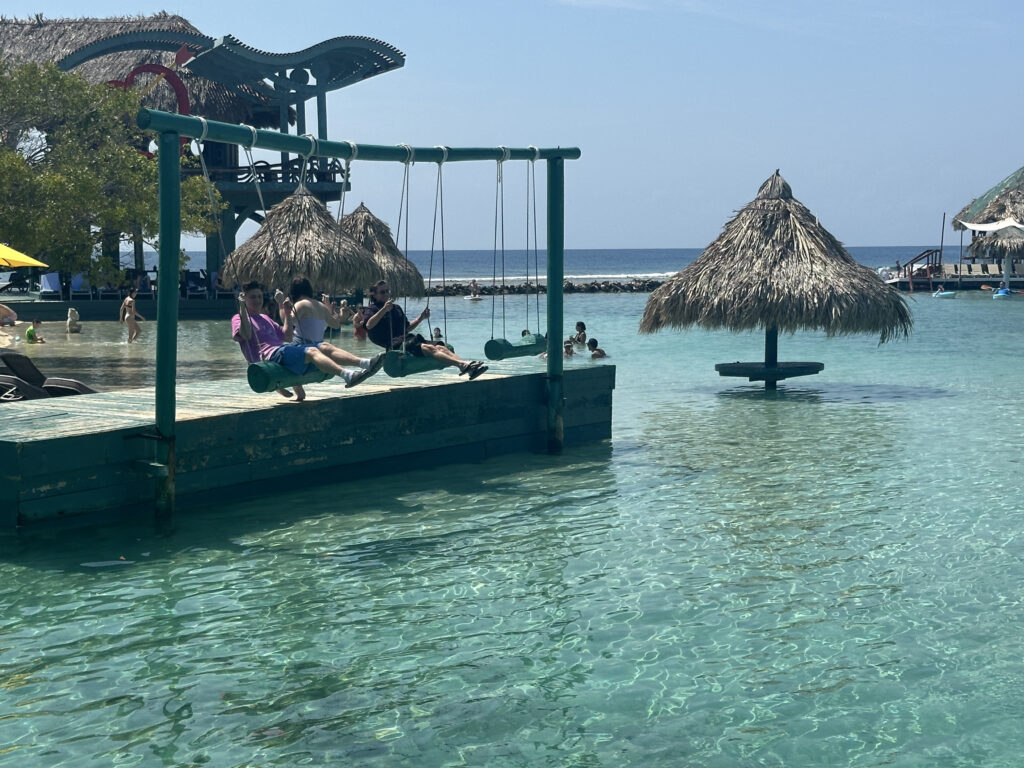 people on a swing set in a body of water