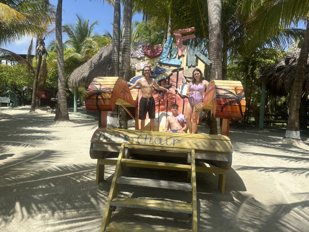 a group of people standing on a wooden slide in front of palm trees