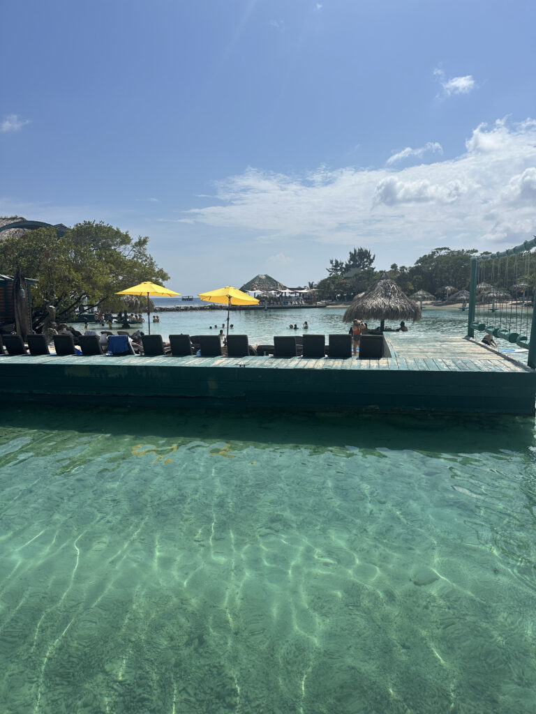 a dock with chairs and umbrellas on the water