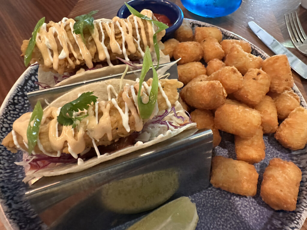a plate of tacos and tater tots