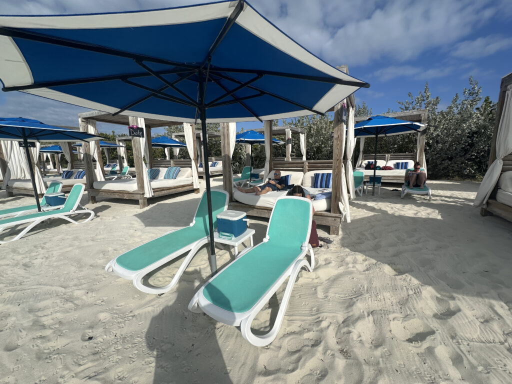 a beach with chairs and umbrella