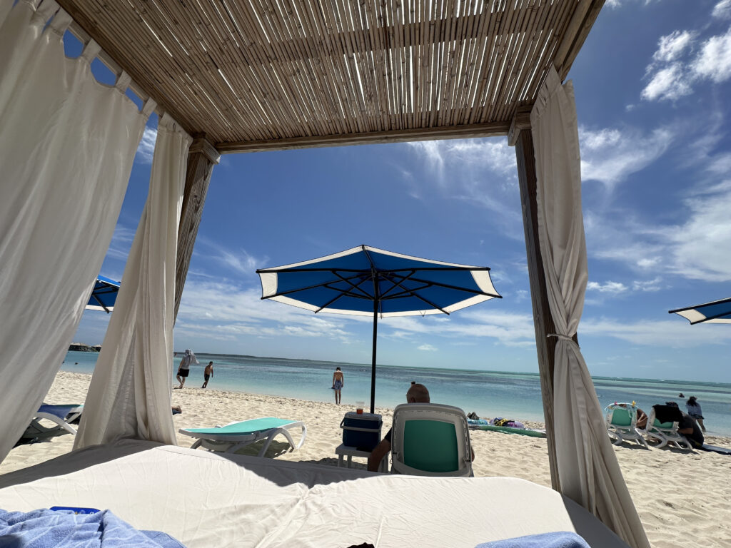 a beach with a canopy and chairs and umbrella