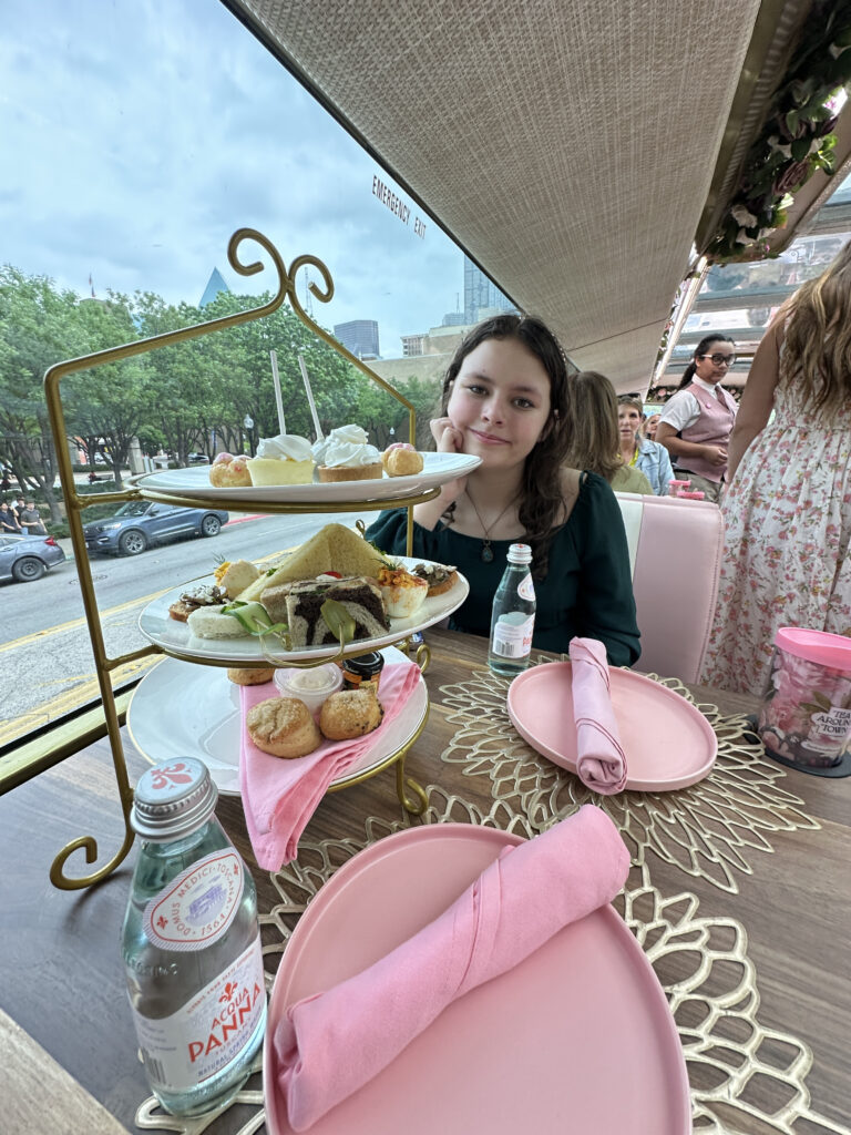 a girl sitting at a table with food on it