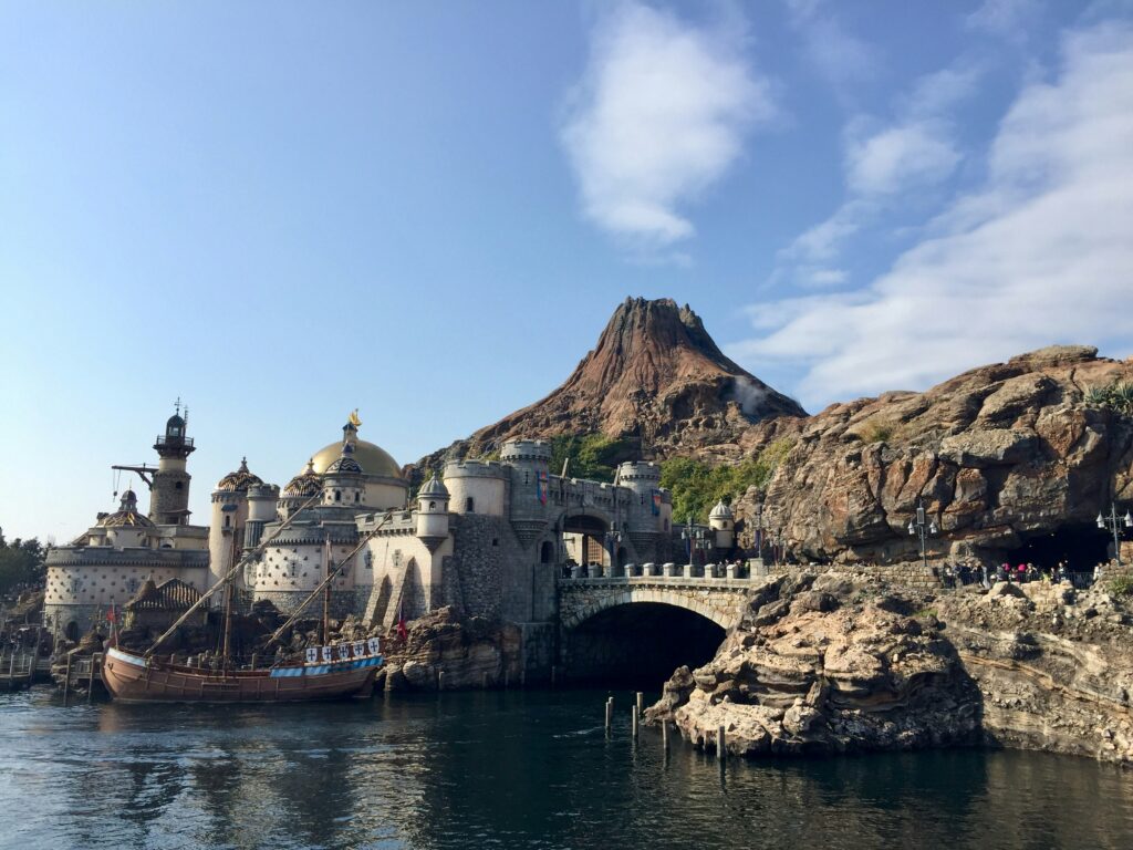 a castle on a rocky hill with Tokyo DisneySea in the background