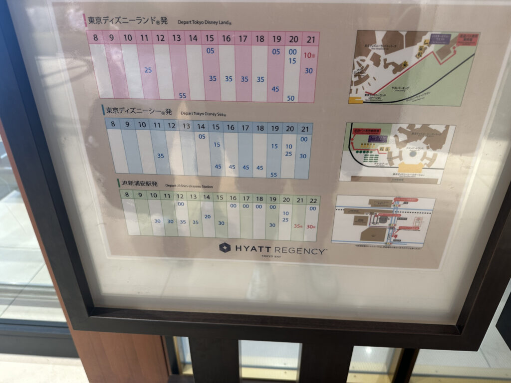 The image shows a framed schedule and map display at the Hyatt Regency Tokyo Bay. It includes departure times for shuttle services to Tokyo Disneyland, Tokyo DisneySea, and JR Shin-Urayasu Station. The schedule is organized in a grid format with times listed under each hour. There are also small maps on the right side, likely indicating routes or locations related to the shuttle services.