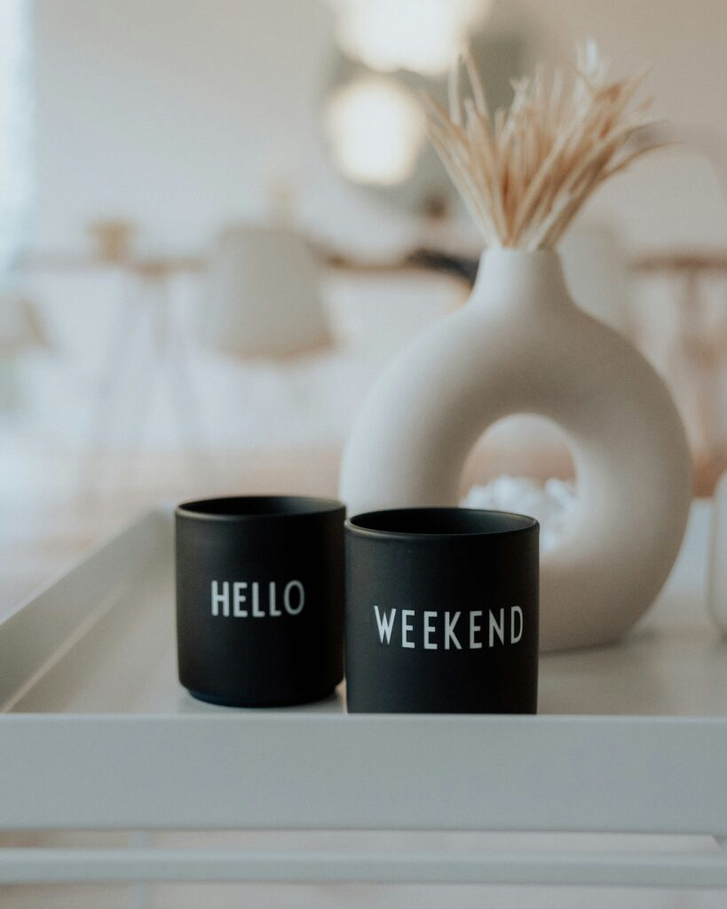 two black mugs with white text on a white tray